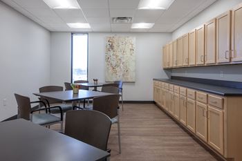 a dining room with tables and chairs in a room with wooden cabinets